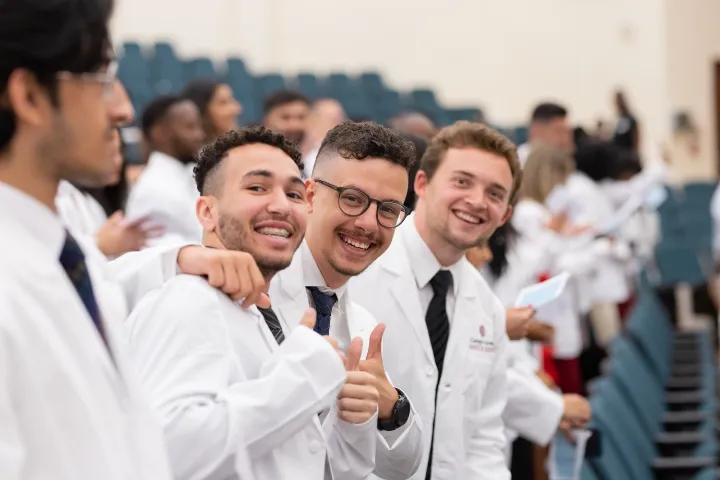 طلاب طب يرتدون المعاطف البيضاء بسعادة